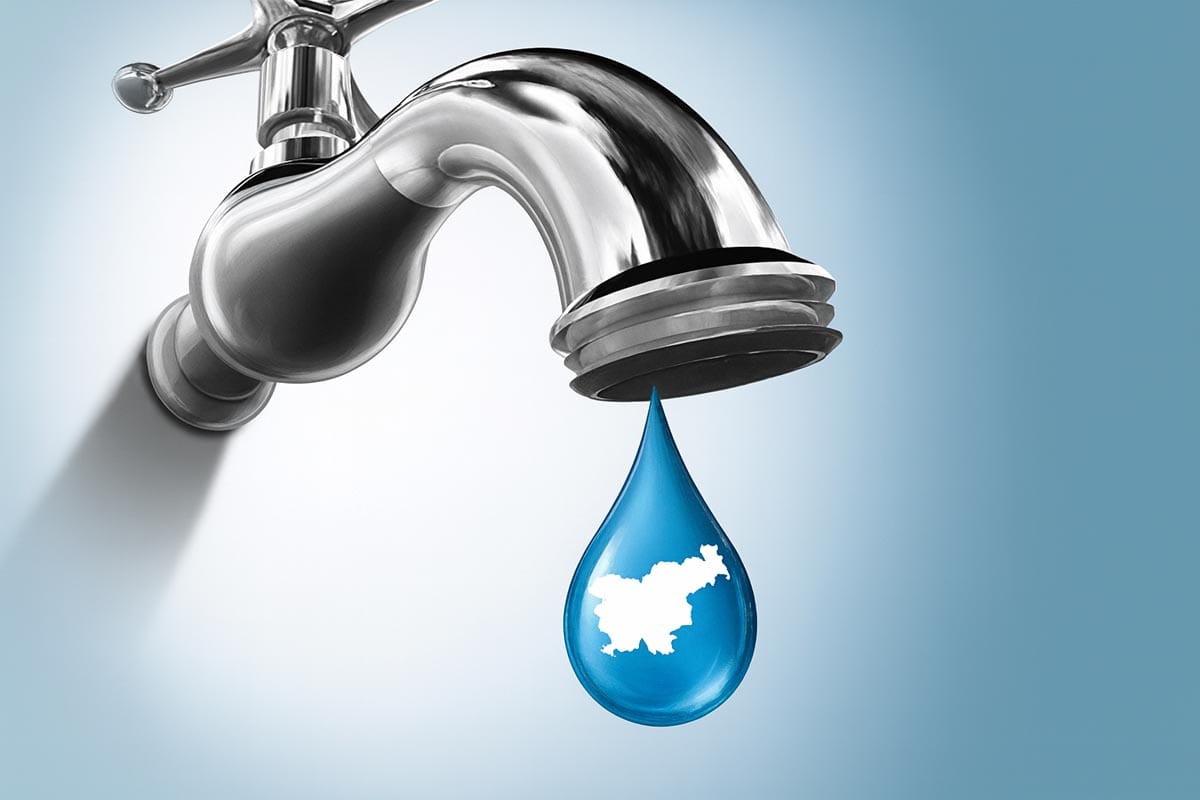 Kovinska vodna pipa, iz katere kaplja modra kapljica vode z belo silhueto Slovenije v notranjosti