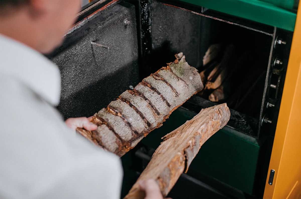 Nalaganje suhih polen v kotel na lesno biomaso za čistejše izgorevanje in manj trdih delcev