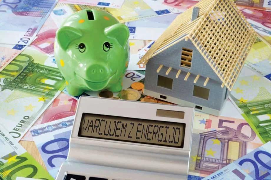Varčevanje z energijo z Eko sklad kreditom – simbolična podoba hranilnika, makete hiše in kalkulatorja