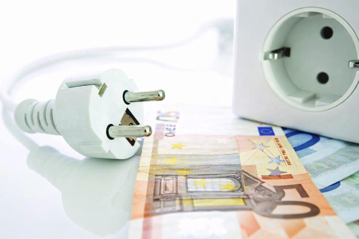 Vtičnica in električni vtič ob evrskih bankovcih – simbol rasti cene elektrike