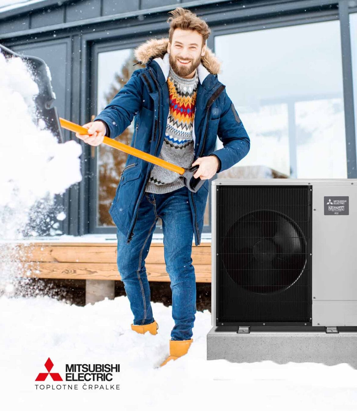 Moški odstranjuje sneg ob hiši s toplotno črpalko Mitsubishi Electric Zubadan, ki zanesljivo ogreva tudi pri nizkih temperaturah