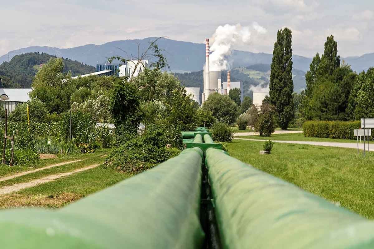 Toplovod in industrijski dimniki v ozadju – poraba fosilnih goriv v slovenski energetiki