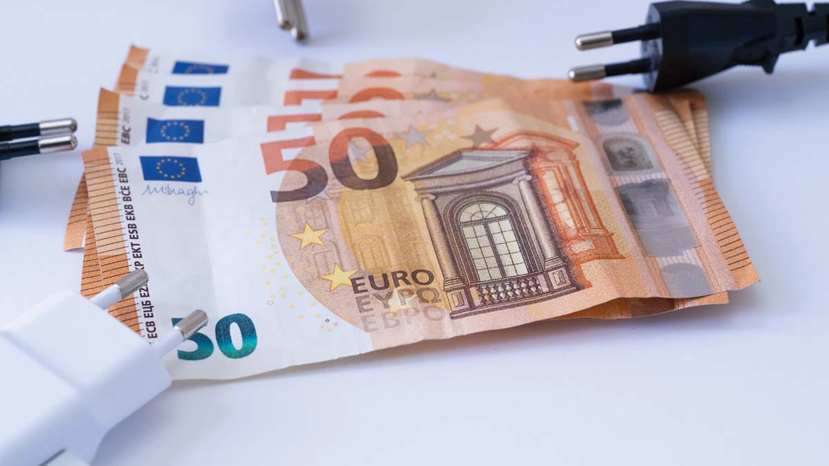 Evrski bankovci in električni vtiči kot ponazoritev stroškov električne energije