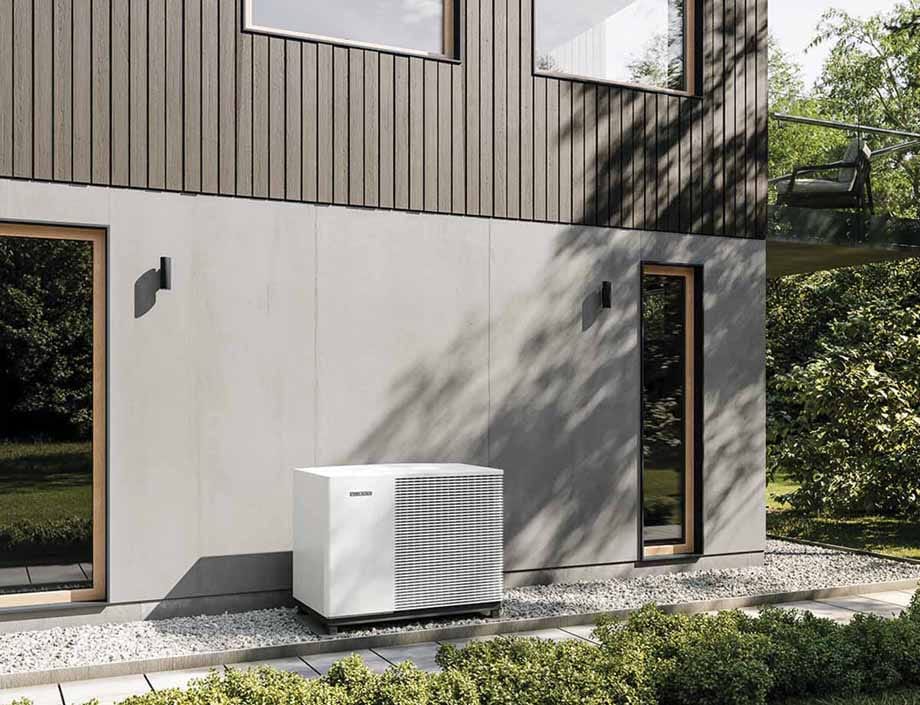 Toplotna črpalka Stiebel Eltron HPA-O Plus v beli izvedbi ob sodobni stanovanjski hiši